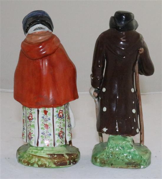 A pair of Staffordshire pearlware figures of an elderly lady and gentleman, c.1830, height 18cm (7.1in.), restorations